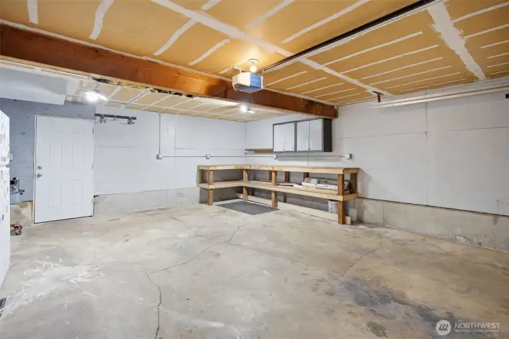 Photo of the garage with rear door to amazing back yard and great workbench area.