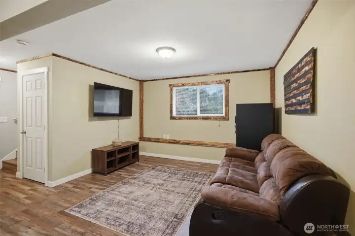 Another view of the lower level reck room. Look at the beautiful burned pine trim which gives this room a comfortable vibe and looks great with the new LVP floors.
