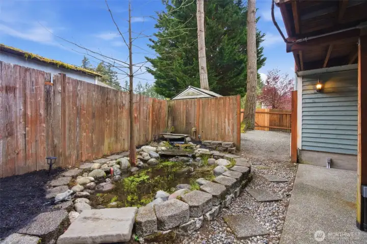 View of the back yard waterfall and pond area. Just beyond this a shed and more outdoor living space.