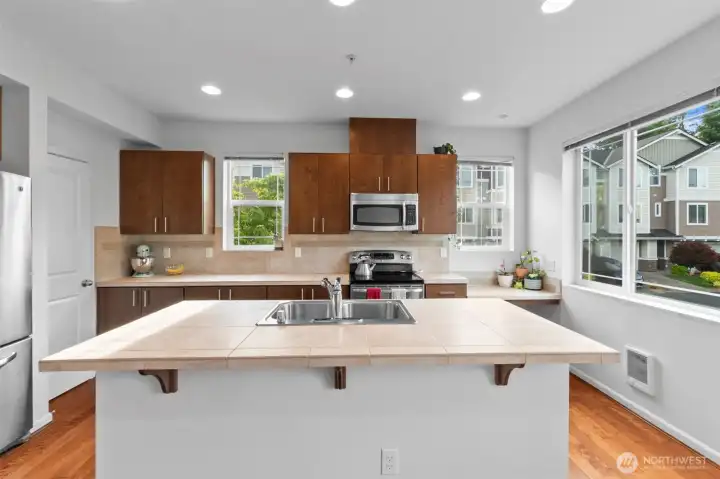 Large island with tons of room for food prep! plus warm wood cabinets and tile counters in immaculate condition, & S/S appliances. Large island with tons of room for food prep! plus warm wood cabinets and tile counters in immaculate condition, & S/S appliances.