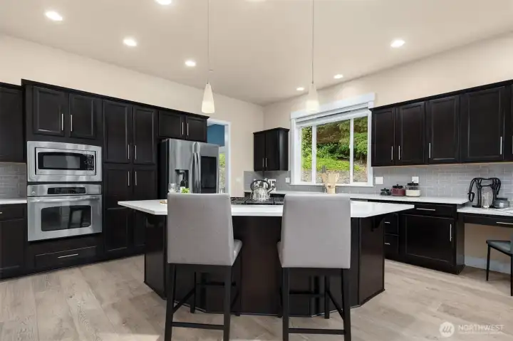 Gourmet kitchen features lots of storage, a pantry, gas range, & new quartz countertops.
