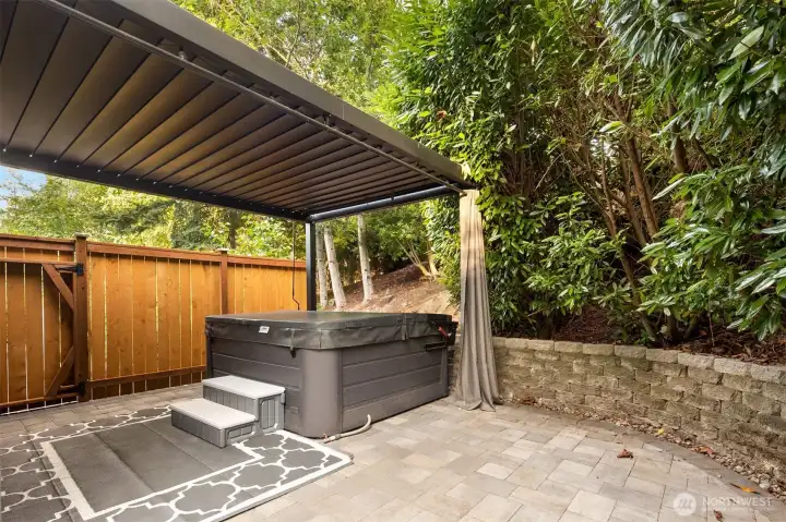 Hot tub is tucked away for privacy. Features louvered pergola and pre-wired TV.