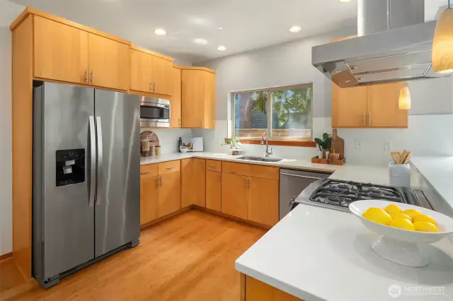 Gas cooktop with stainless vent hood.