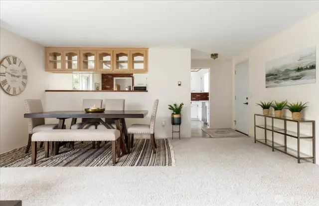Looking to the dining area, entry and kitchen beyond.