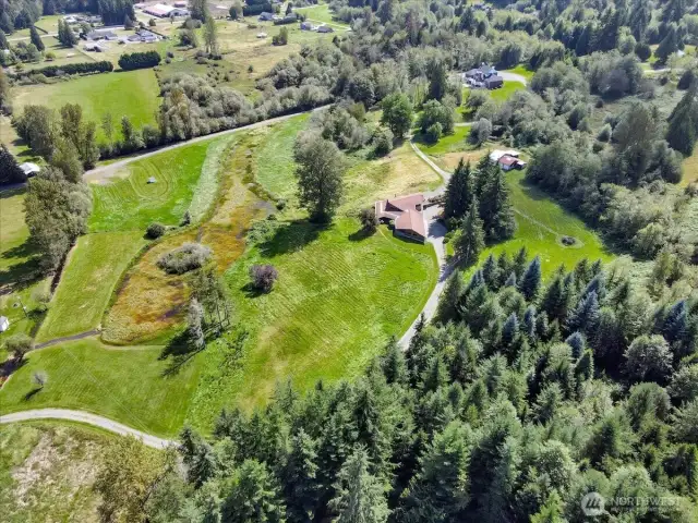 28 acres teeming with wildlife, lush meadows, a natural pond, and a flowing stream.