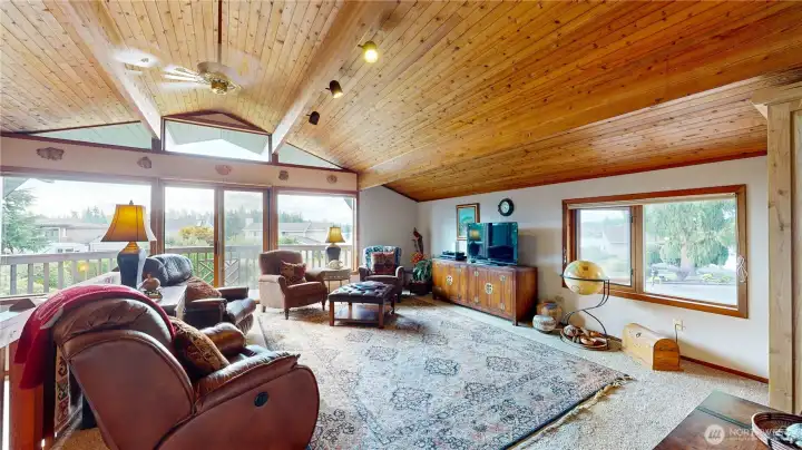 Spacious loft with vaulted wood ceilings, abundant natural light, and balcony access with lake views.