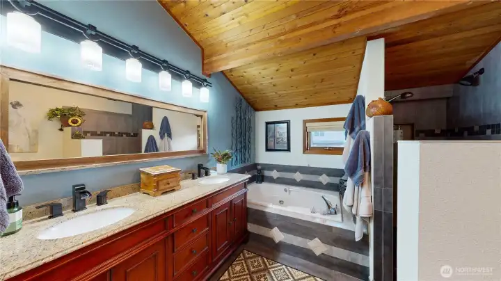 Primary bath with double vanity, large mirror, soaking tub, and walk-in shower.