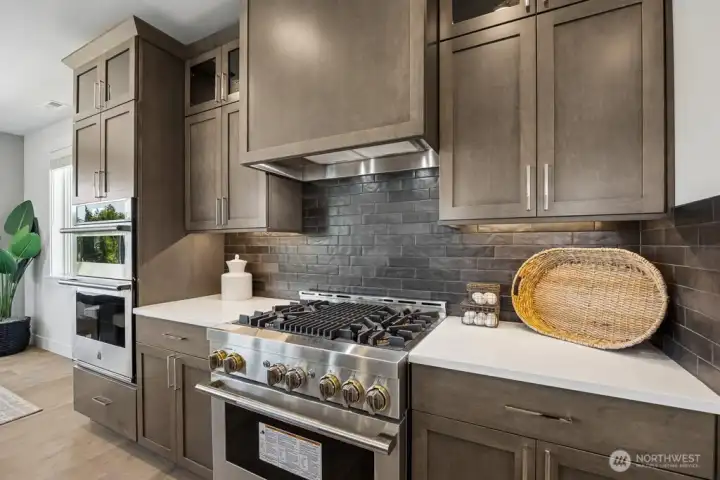 Gas range and full height tile backsplash.