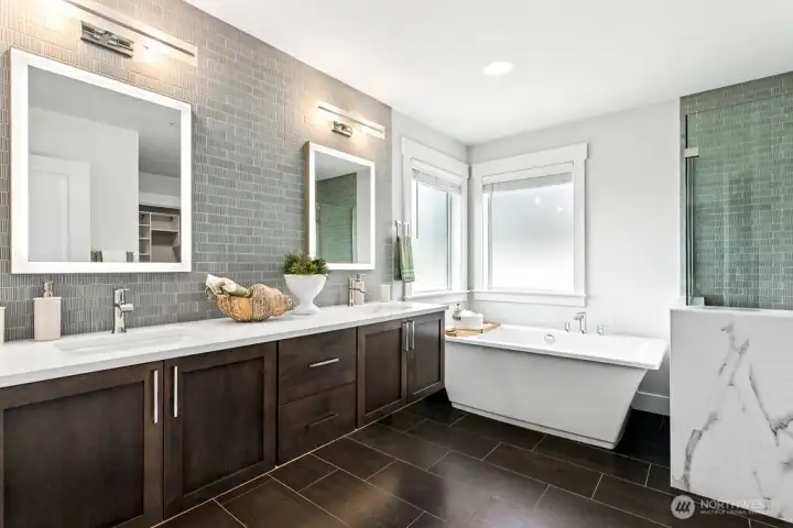 Primary bathroom with heated floors, soaking tub, back-lit mirrors, and floating vanities