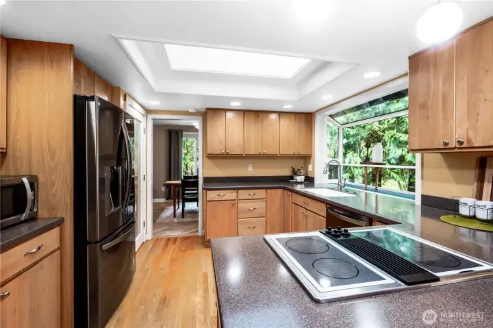 Kitchen looking into dining room showing the natural light coming from the newly replaced windows and solar powered, rain sensing skylights .