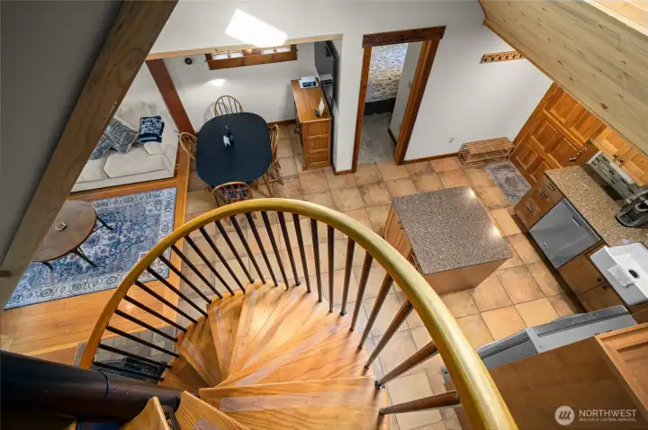 Great view from the oversized spiral staircase looking down to the dining room and kitchen.