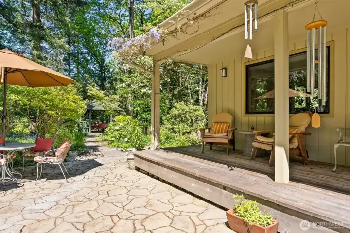 Covered front porch and sun soaked patio and beautiful Wisetria vines welcoming you.