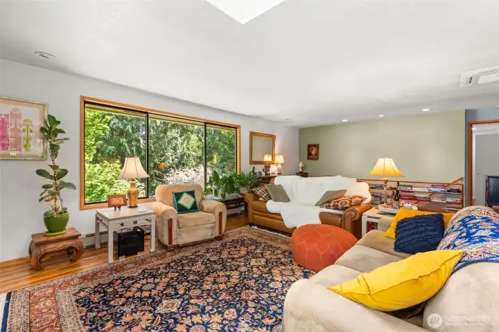 Living room with hickory hardwood floors, oversized windows and skylight.