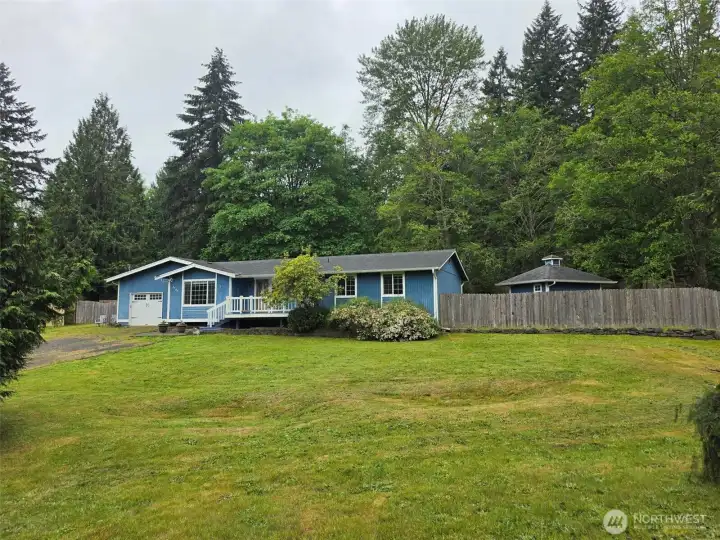 Home on generous front yard. Outbuilding office/studio to right in back yard.