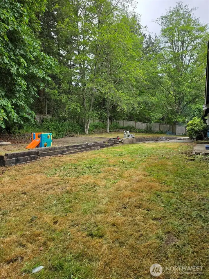 Private back yard with patio fire pit at the end by outbuilding. Private hot tub or lounging deck.