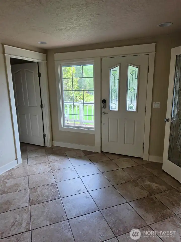 Entry with 1/2 bath to left and office/den/family room thru french dorrs at right.