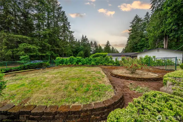 This entire area is a brick patio - with raised beds ready for flowers or veggies. Some already have roses!