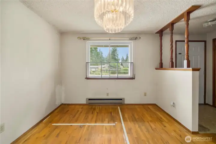 Dining room is open to the living room and has recently exposed hardwood flooring.