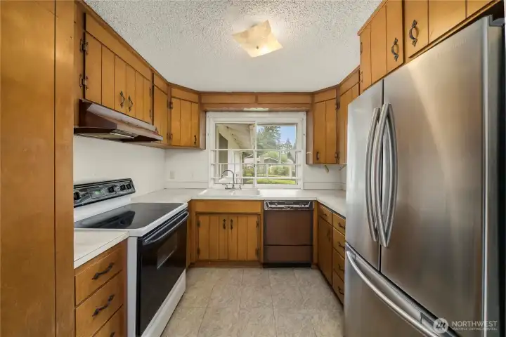 Efficient kitchen has potential for expansion. The wall on the right backs to the dining room and the wall on the left backs to the large Bonus room.