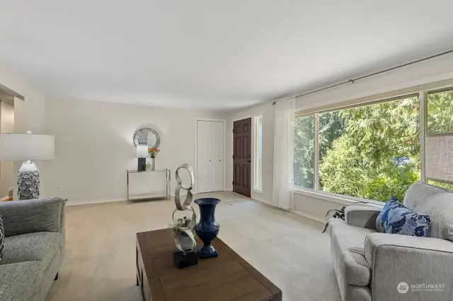 Big inviting living room with a wall of windows looking out into the greenery.