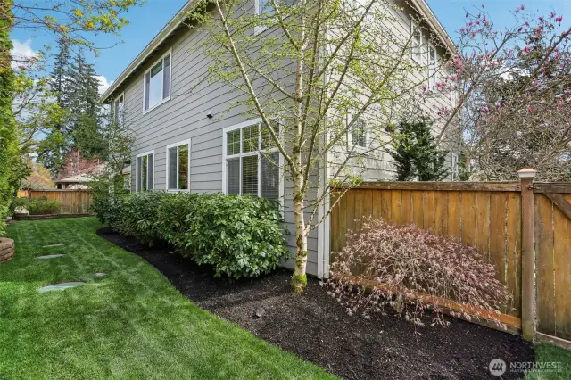The fully fenced backyard offers privacy, while the beautifully landscaped yard includes a sprinkler system