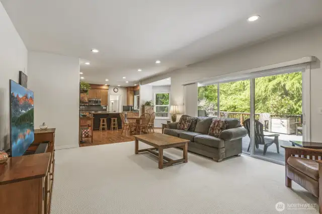The informal gathering room features a stone surround gas fireplace and sliding door to the deck.