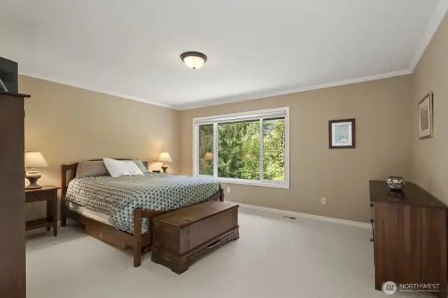 The primary suite with crown molding and tranquil backyard views features 2 walk-in closets and an updated 5 piece bathroom with soaking tub, tiled shower, dual vanities and tile floor.