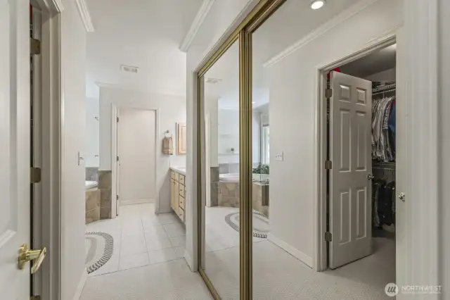 The primary suite with crown molding and tranquil backyard views features 2 walk-in closets and an updated 5 piece bathroom with soaking tub, tiled shower, dual vanities and tile floor.