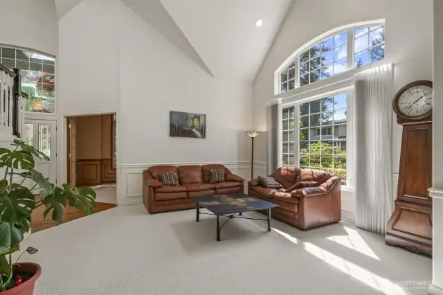The open and spacious formal living and dining rooms boast tall vaulted ceilings and wainscoted walls.