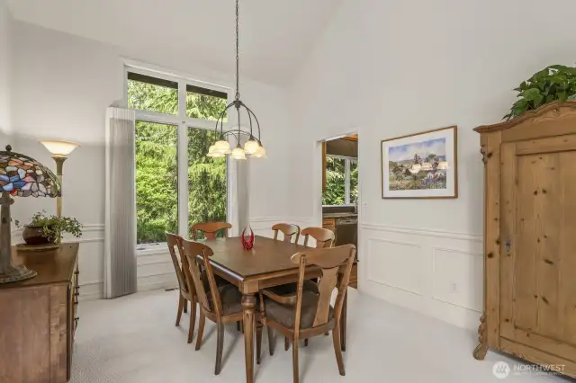 The open and spacious formal living and dining rooms boast tall vaulted ceilings and wainscoted walls.