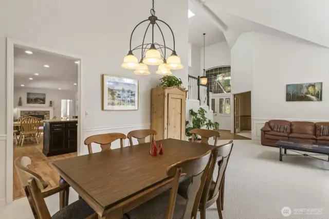 The open and spacious formal living and dining rooms boast tall vaulted ceilings and wainscoted walls.