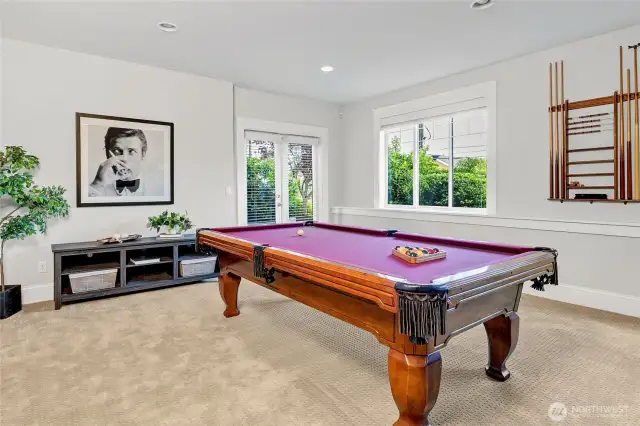 Spacious rec room with pool table and media area.