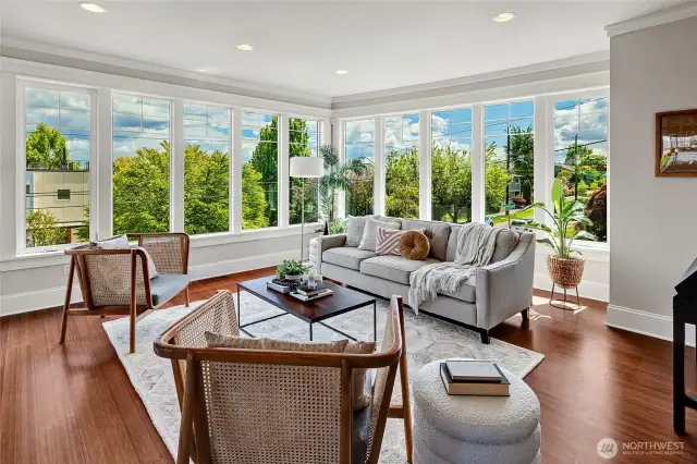 The sunlit living area is flanked by windows that capture views of Lake Washigton, Mount Rainier, and the Cascades.
