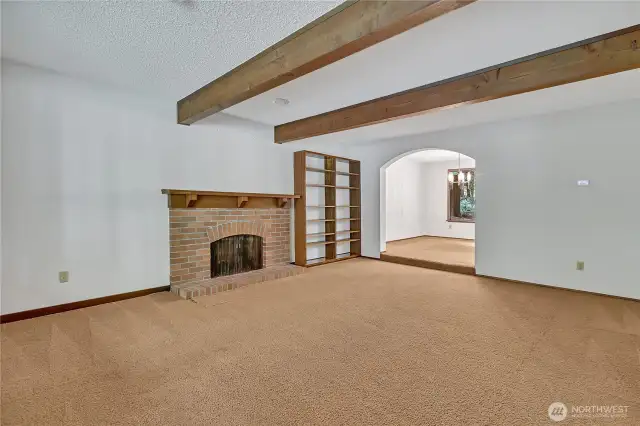 Formal Living Room with wood burning fireplace and exposewd wood beams.