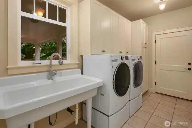 Mud room with porcelain farm sink, custom cabinetry, washer/dryer and garage access