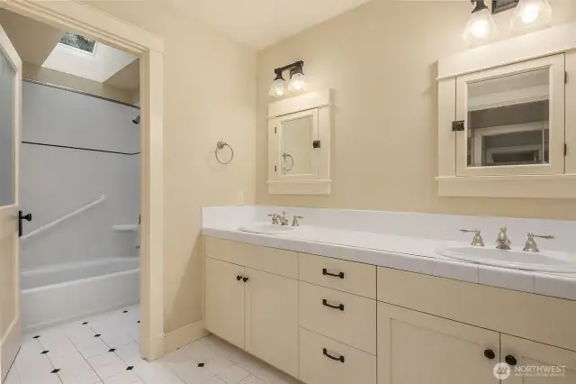 Upper level full bathroom with double vanity and skylight