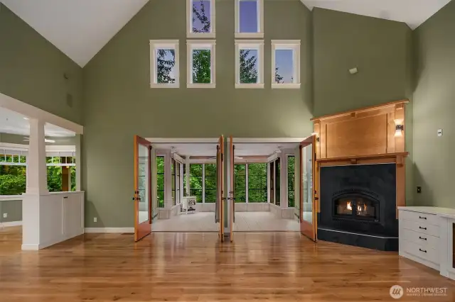 Two story living room with high-efficiency wood burning fireplace insert with blower, slate surround with custom mantle including built-in media cabinetry