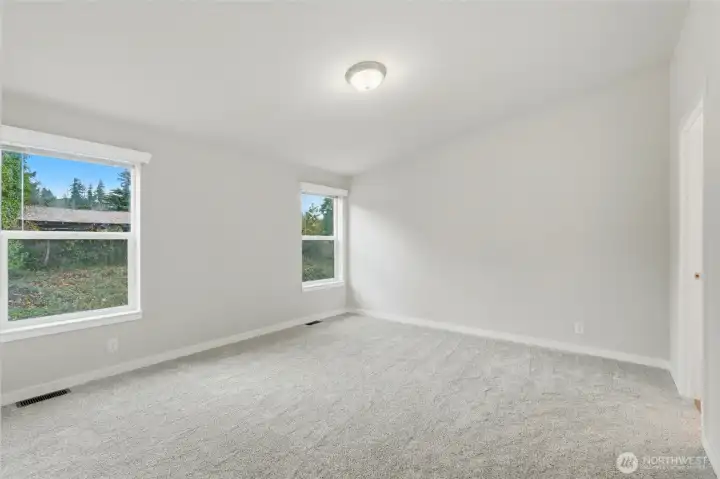 Cozy carpeting in bedroom adds comfort for a relaxing retreat.