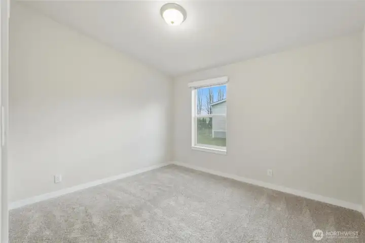 This photo showcases the second bedroom, carpeted for comfort and an inviting atmosphere.