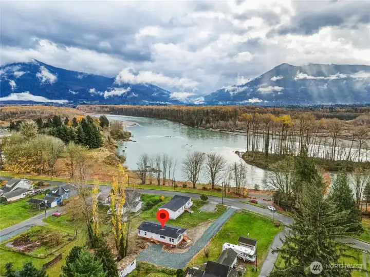 Stunning natural beauty surrounds the home--river, mountain, sky.