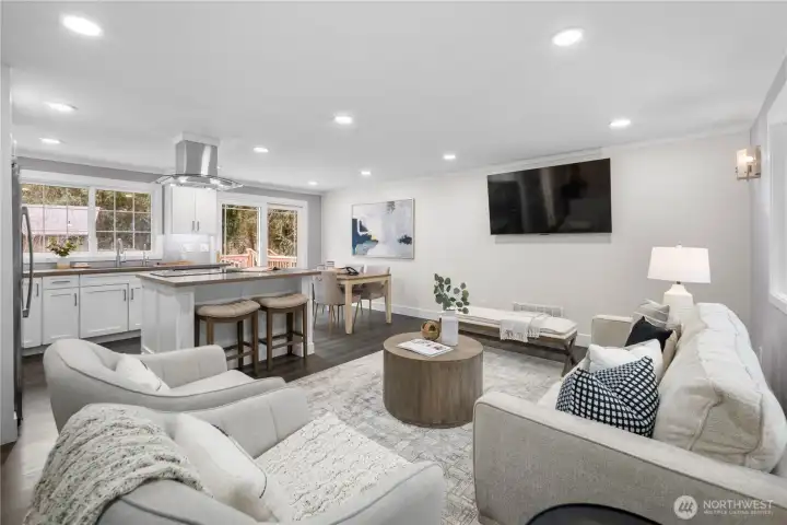 The kitchen’s breakfast bar anchors the space with clean lines and quartz counters that add both durability and a refined finish. The extended counter creates a natural gathering point, perfect for casual meals, morning coffee, or spreading out a laptop for work or study. Thoughtfully placed outlets on both sides of the bar allow two people to plug in and work comfortably together, blending function seamlessly into the design. With seating tucked neatly beneath, the breakfast bar keeps the main living area open while offering a practical everyday workspace that feels connected to the heart of the home.    Subtle panel detailing wraps both sides of the island, giving it dimension and architectural presence. Rather than feeling like a simple counter addition, it stands as a beautifully finished focal point that adds character and intention to the kitchen.    The home is equipped with a Brennan heat pump system with central air conditioning, providing reliable year round comfort.