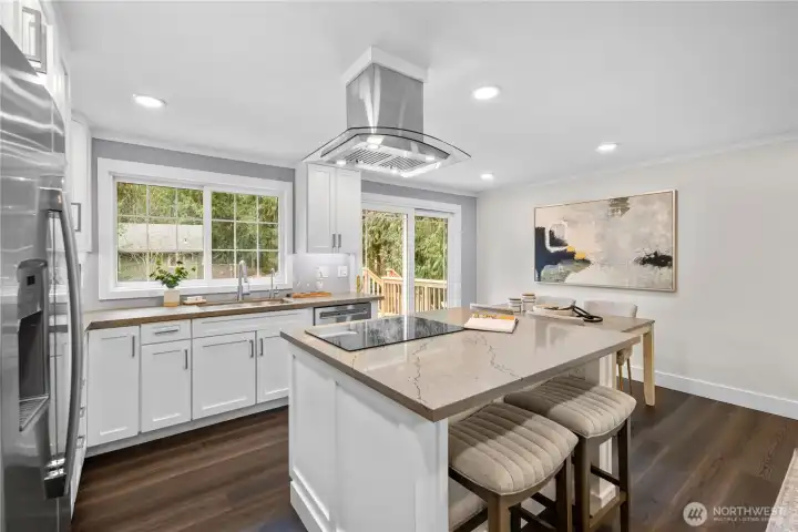 Remodeled in 2025, the kitchen features all new GE appliances installed in 2025. Crisp modern cabinetry stretches along the walls, offering abundant storage while keeping the lines clean and refined. Soft under cabinet lighting adds a warm glow across the counters in the evening, highlighting the thoughtful design and creating an inviting atmosphere for both everyday living and entertaining. In the evenings, that gentle illumination provides just the right amount of light for meal prep or late night conversations, allowing the space to feel comfortable and relaxed without relying solely on overhead lighting. Quartz counters extend along both sides, providing ample room for preparing meals, arranging ingredients, or keeping small appliances within reach. Multiple outlets along the backsplash support everyday cooking and baking needs while maintaining the kitchen’s cohesive look.