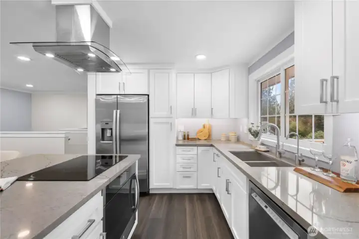 The sink itself is generously sized with a clean, modern profile, paired with an updated faucet that offers both reach and ease of use for rinsing produce, filling pots, and everyday tasks. Finished in stainless steel to coordinate with the appliances, the deep double basin design provides flexibility for soaking and washing at the same time. A graceful swan neck faucet is complemented by a matching drinking water dispenser, creating a cohesive and polished look. The dishwasher sits immediately beside it, allowing dishes to move smoothly from sink to machine. With multiple button selections and wash settings, the dishwasher supports a range of loads with ease. A built in garbage disposal simplifies cleanup, making after dinner routines quick and efficient.