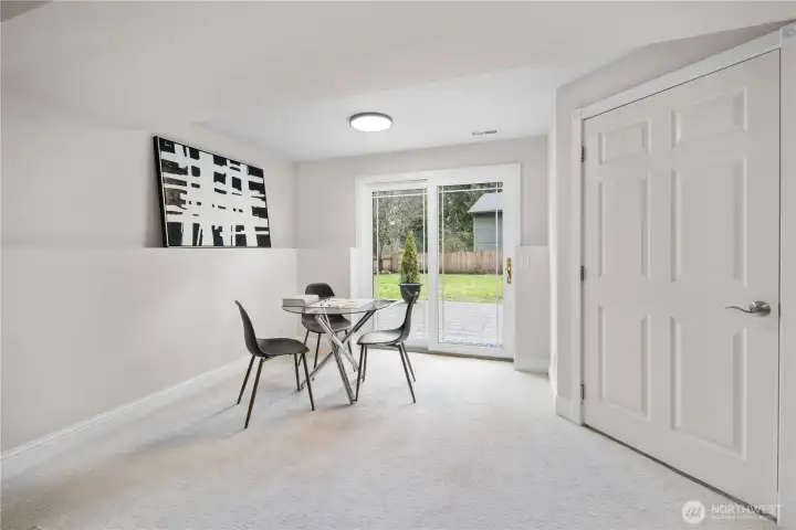 Sliding glass doors mirror the dining room above, featuring clean-lined grilles set within crisp white framing. They draw in natural light and open easily to the yard, creating a seamless extension of the living space while maintaining that subtle architectural detail seen throughout the home.