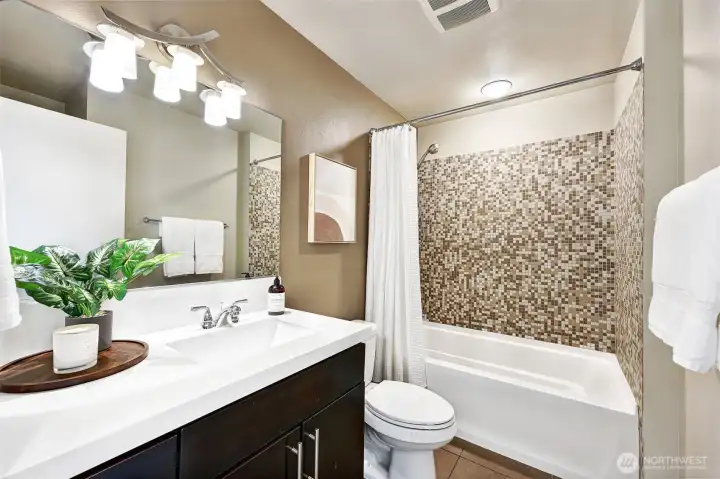 Full bathroom with tile surround and Quartz counters
