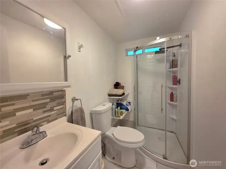 Updated sink with backsplash. Stylish shower.