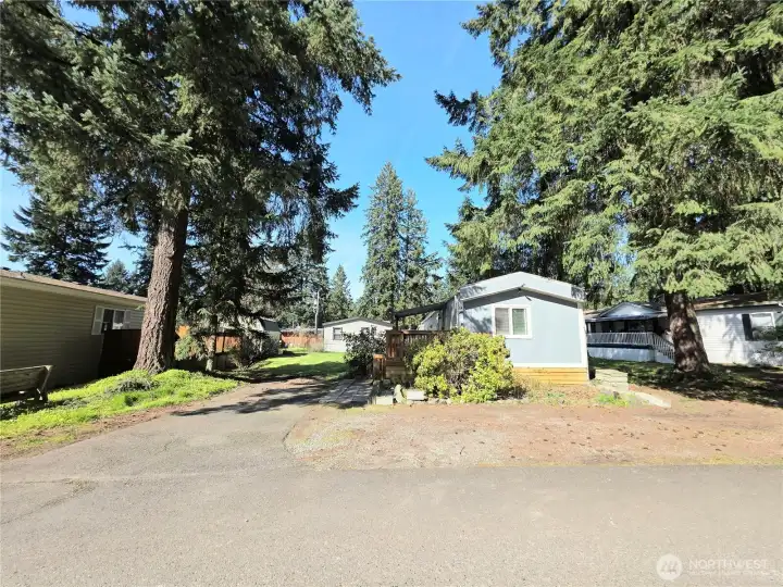This home feels BIG! With a designated parking space and nice distance from the neighbors. The matured trees and landscaping will make you feel close to nature.