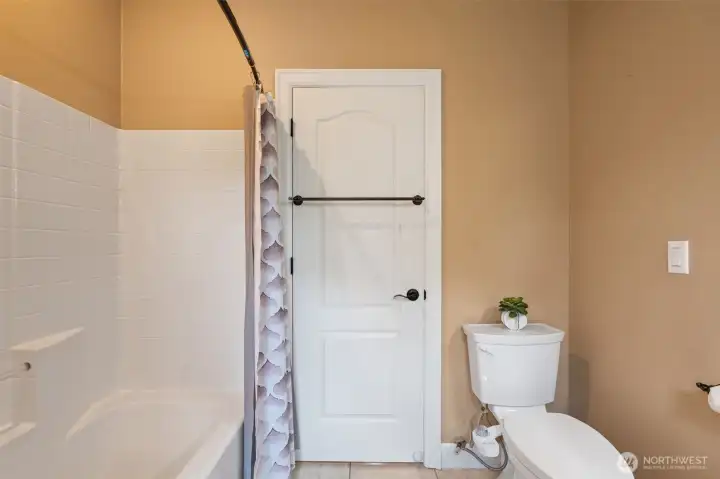 Main bathroom with bathtub and lots of storage shelves