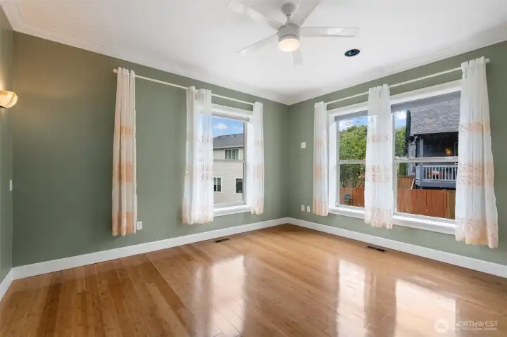 Primary Bedroom with ceiling fan, wall sconces