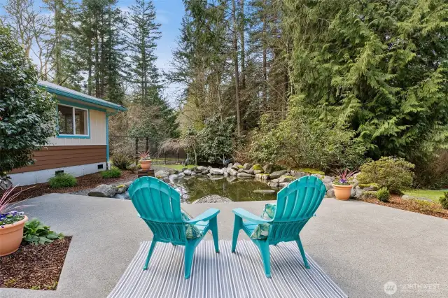 Private courtyard patio surrounding a pond. In the background, the yard behind the 3 car garage is fenced in for your 4-legged friends.